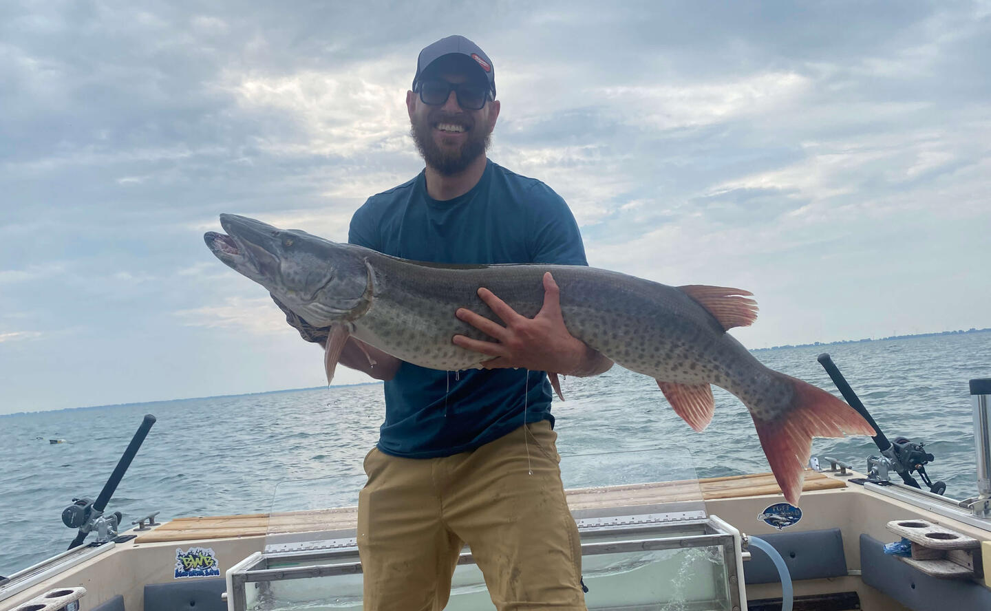 Reaper Musky Charters Man holding a huge musky that he caught.
